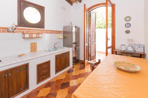 una grande cucina con tavolo e frigorifero di Villa Melisa a Fontane Bianche