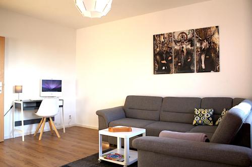 uma sala de estar com um sofá e uma mesa em Cottbuser Gästewohnungen em Cottbus