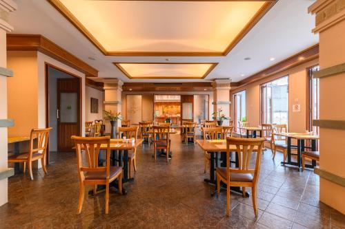 a dining room with wooden tables and chairs at Phuket Kata Resotel in Kata Beach