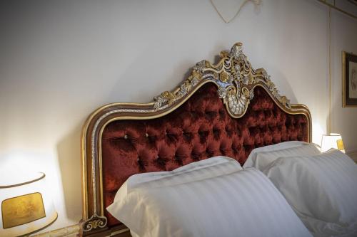 two beds in a bedroom with a red headboard at Les Suite Royales in Sassari