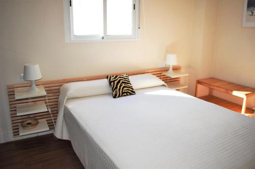 um quarto com uma cama branca e uma almofada em Playa Pau Pi Eivissa AP945 em Oliva