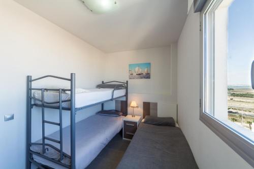a bedroom with two bunk beds and a window at Aqua Nature 27D in La Mata