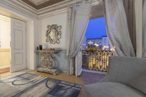 a room with a balcony with a view of a city at Les Suite Royales in Sassari