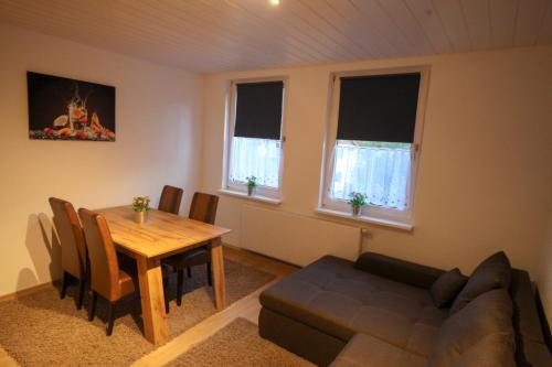 a living room with a dining room table and a couch at FeWo Bergblick in Osterode