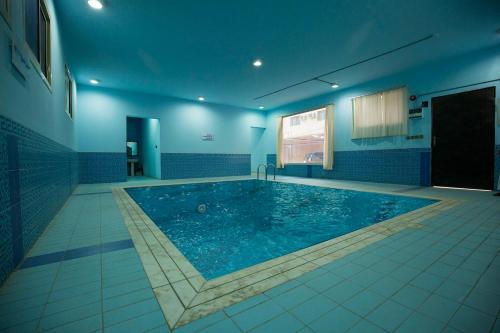 布賴代的住宿－Shams Alshate شمس الشاطئ，蓝色墙壁的房间中的一个大型游泳池