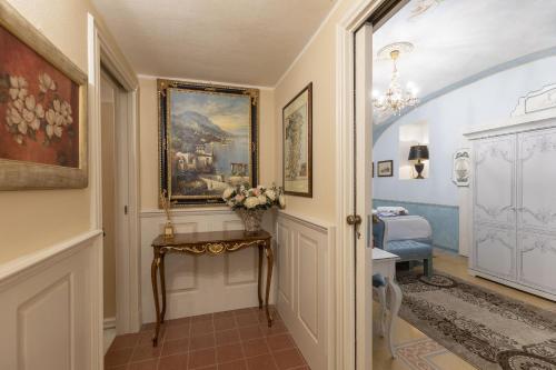 a hallway with a painting on the wall and a table at Les Suite Royales in Sassari
