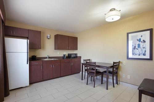 a kitchen with a table and a white refrigerator at La Quinta by Wyndham Meridian / Boise West in Meridian