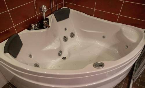 a white bath tub with a faucet in a bathroom at Hotel Rukatonttu in Ruka