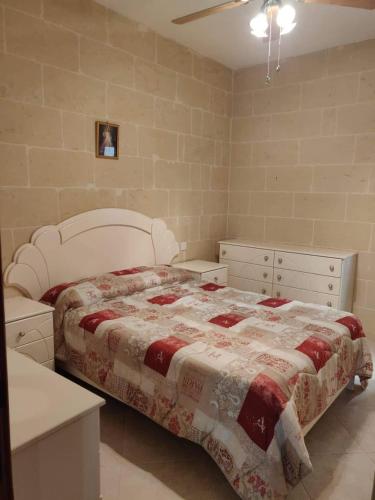 a bedroom with a bed and two dressers at Minute walk to the beach in Munxar