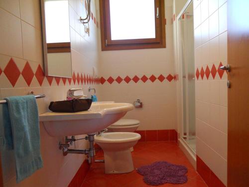a bathroom with a sink and a toilet and a mirror at Villaggio Tulipano in Bibione