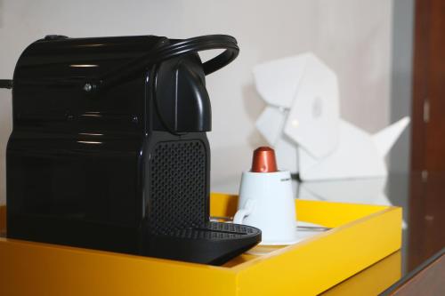 a black coffee maker sitting on a yellow box at FCH Hotel Expo Adults only in Guadalajara