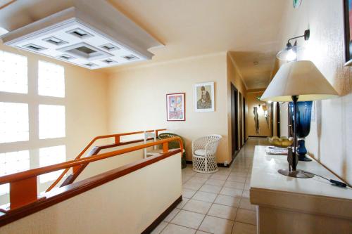 Cette chambre dispose d'un couloir avec une lampe sur une table. dans l'établissement Hotel Le Ceinturon, à Hyères