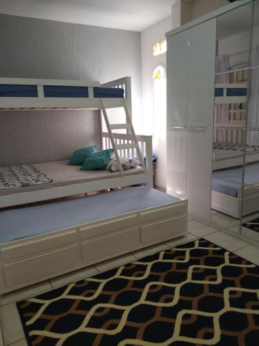 1 dormitorio con litera y alfombra en Casa de verão, en Arraial do Cabo