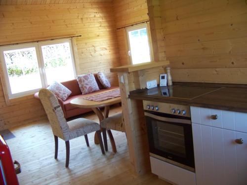 a kitchen with a table and a couch in a cabin at Ferienhaus Brunnenweiher in Kißlegg