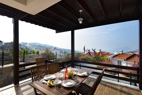 a wooden table with food on top of a balcony at Bodrum sea view villa with access to private beach in Bogazici