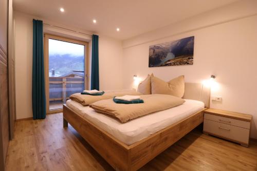 a bedroom with a large bed with a large window at Apart Kreidl in Mayrhofen