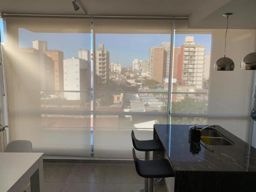 a kitchen with a large window with a view of a city at Cálido y Moderno Departamento in Rosario