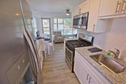 a kitchen with a sink and a stove top oven at Mill House Lodge - Flat Rock in Hendersonville