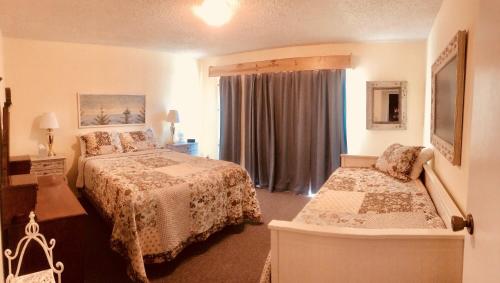 a bedroom with two beds and a window at Driftwood Inn in Homer