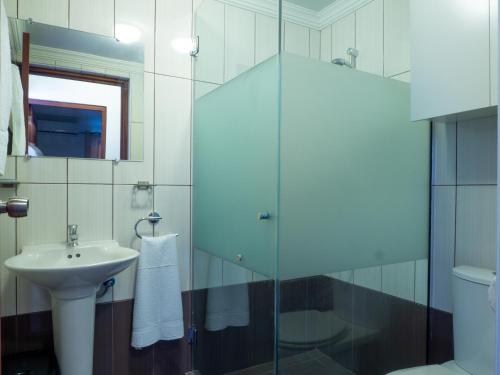 een badkamer met een glazen douche en een wastafel bij Sirena Resort Curaçao in Willemstad
