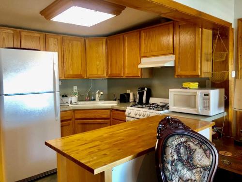 a kitchen with wooden cabinets and a white refrigerator at Driftwood Inn in Homer