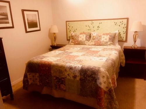 a bedroom with a bed with a floral bedspread at Driftwood Inn in Homer