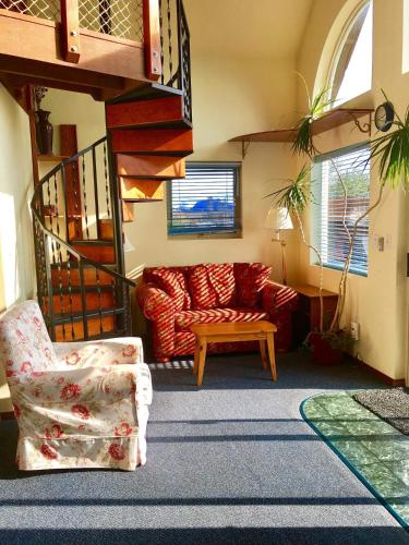 a living room with a red couch and a chair at Driftwood Inn in Homer