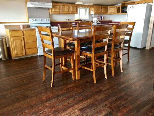 a kitchen with a wooden dining table and chairs at Driftwood Inn in Homer