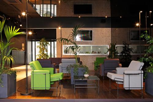 a lobby with green and white chairs and plants at Lifestyle Hotel Vitar - Adults Only in Bol
