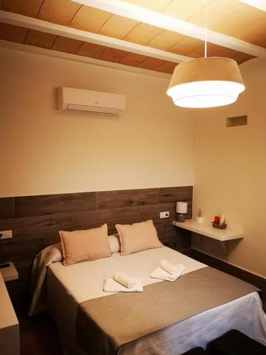 a bedroom with a bed with two towels on it at 4nudos playa in San José