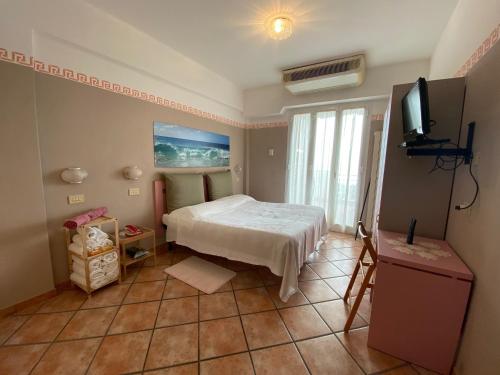 a bedroom with a bed and a television in it at Appartamenti La Pineta in Marina di Andora