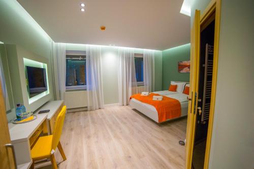 a bedroom with a bed with an orange blanket at Villa Umberti in Sibiu