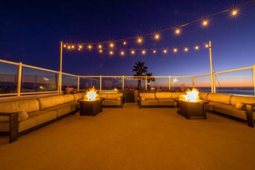a deck with couches and fires on a balcony at night at SeaCrest Oceanfront Hotel in Pismo Beach