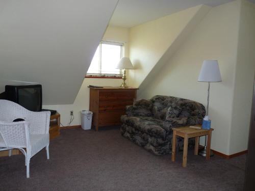 a living room with a couch and a tv at Driftwood Inn in Homer