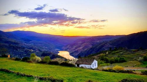 a small white house on a hill with a river at Miradores do Sil Hotel Apartamento in Cristosende