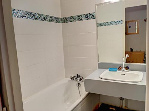La salle de bains est pourvue d'un lavabo, d'une baignoire et d'un miroir. dans l'établissement Aster, à Chamonix-Mont-Blanc