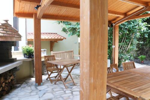 un patio con tavolo e sedie in legno e un camino di Casa Vacanze Il Giardino - Appartamento Castagno ad Aritzo