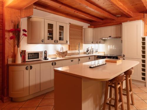une cuisine avec des placards blancs et un comptoir dans l'établissement Chalet Rocher, à La Thuile Sainte-Foy-Tarentaise