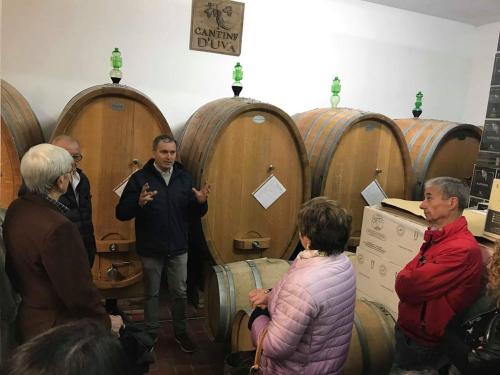 un grupo de personas de pie en una habitación con barriles de vino en I Dolci Grappoli, en Larino
