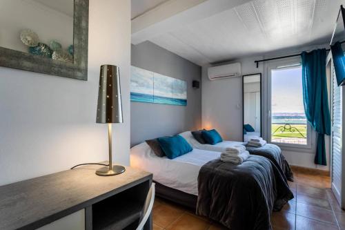 1 dormitorio con cama, escritorio y ventana en Hôtel Le Mistral, en Marsella