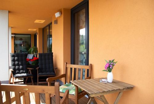 a table and chairs on a porch with a vase of flowers at Penzion Na Svahu in Cheb