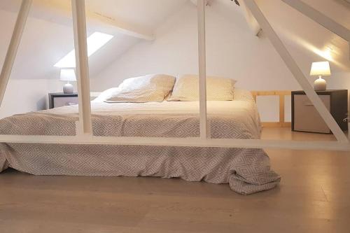 a bedroom with a bed in a attic at Cottage du lac de Chaumeçon avec étang privé in Brassy