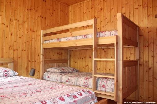 2 Etagenbetten in einer Hütte mit Holzwänden in der Unterkunft Sunlake Magneaz in Champoluc