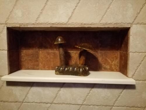 a shelf in a brick wall with a statue of two mushrooms at DIMITRA's VILLAS in Elatochori