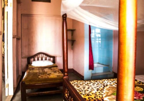 Okla GuestHouse في كامبالا: غرفة نوم بسرير مع مظلة
