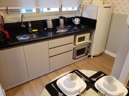 a small kitchen with a stove and a refrigerator at Edifício Vila Real in Balneário Camboriú