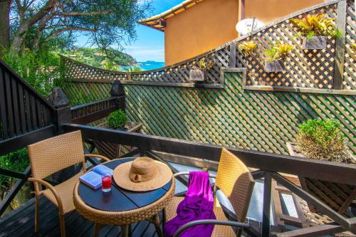 a table and chairs with a hat on a balcony at Chez Pitu Praia Hotel in Búzios
