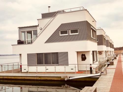 a house on a dock next to the water at Hausboot Elandi in Bitterfeld