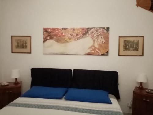 a bedroom with a bed with blue pillows on it at Laetitia in Porto Santo Stefano
