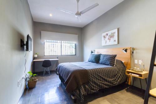 a bedroom with a bed and a desk in it at Casa Alexia in Guadalajara